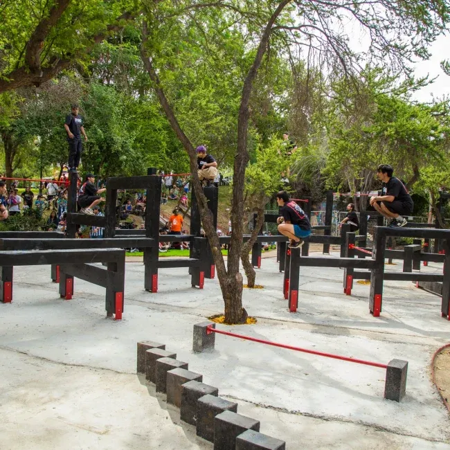 Jóvenes practicando parkour en instalaciones al aire libre hechas durante los proyectos sociales de DeporteLibre.