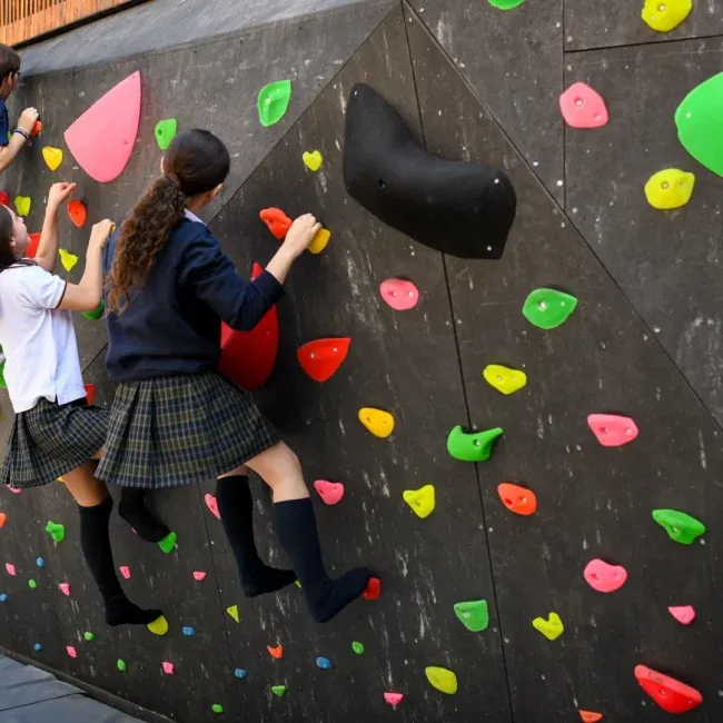 Niñas jugando en una pared para escolares parte de lor proyectos sociales de DeporteLibre en comunidades.