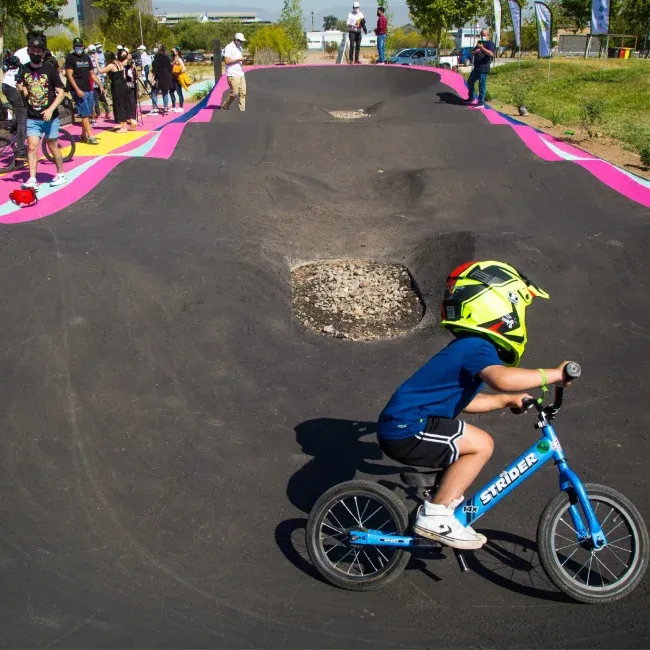 Joven con casco en una pista para bicicletas parte de los proyectos sociales de Deporte Libre para promover la actividad.