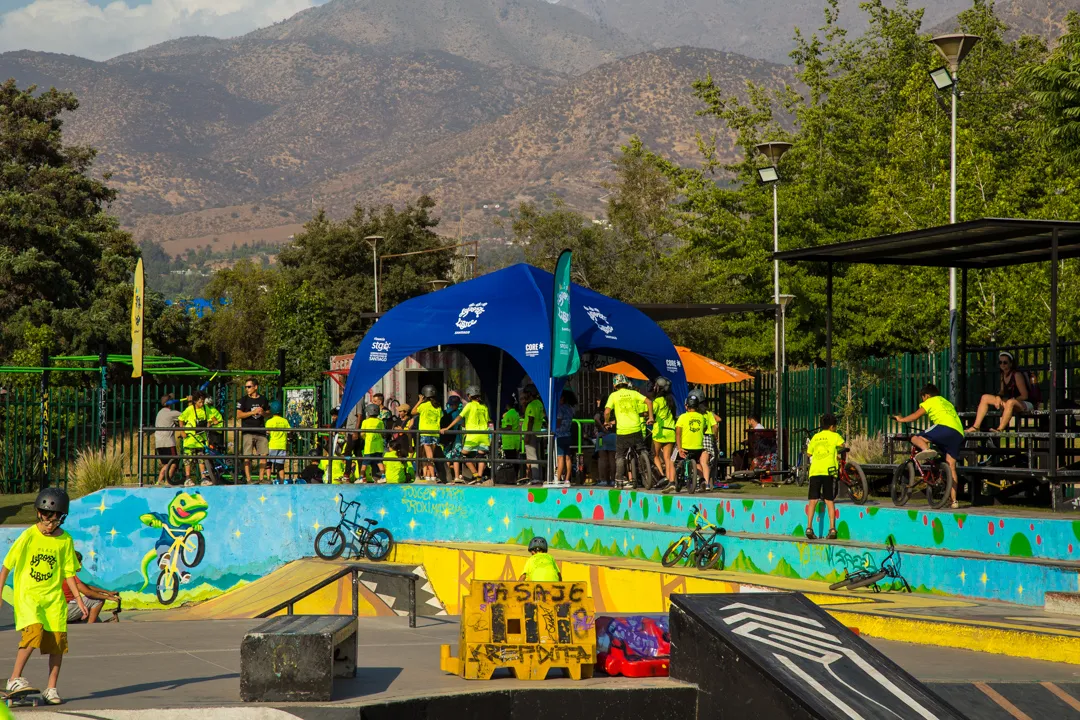 Fotografía de una pista en color azul para practicar BMX durante el día al aire libre y con personas cerca.