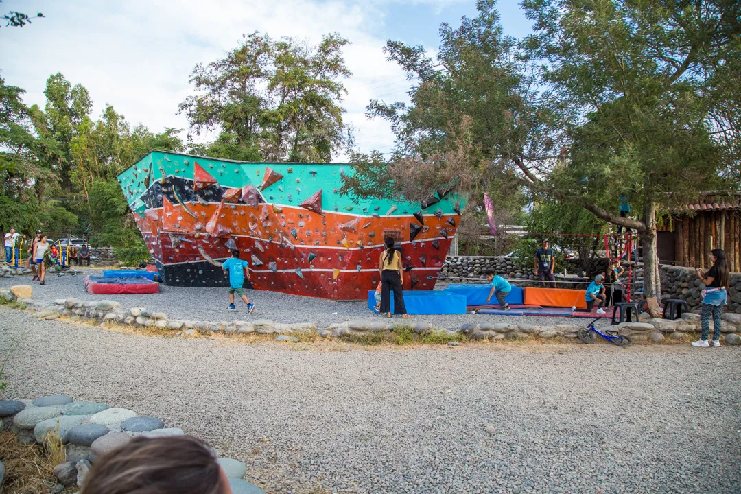 Fotografía de una pared de colores que sirve para practicar escalada al aire libre durante el día en una comunidad.